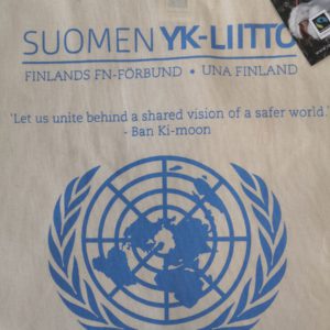 Vaalea kangaskassi, jossa Suomen YK-liiton logo ja YK:n pääsihteerin sitaatti "Let us unite behind a shared vision of a safer world"